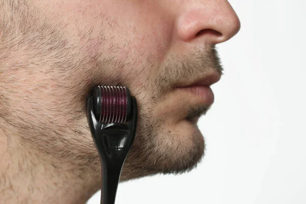 しわの治療とひげの成長のためのマイクロニードルダーマーラーと顔のマッサージ 自宅で簡単かつ安価なスキンケア — ストック写真