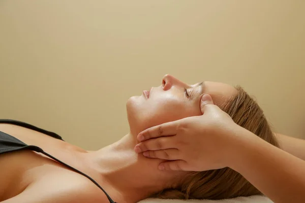 Face massage, a woman in the spa having anti-age face massage