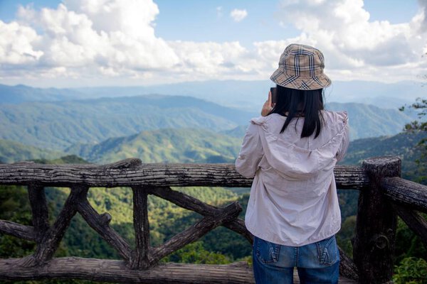 Tourist taking photos of Mountain landscape view and blue sky at nan province.Nan is a rural province in northern Thailand bordering Laos