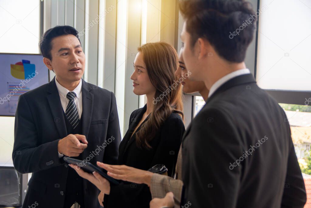 Businessman manager having discussion with team meeting in office meeting room. A Team diverse professionals talking using tablet discussing project strategy, checking corporate plan.