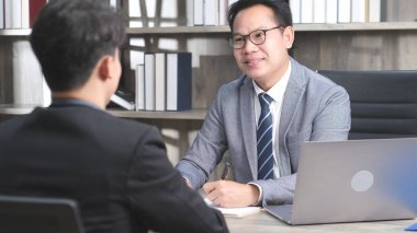 Ofis geçmişinde iş görüşmesi yapan Asyalı adam, iş arama, iş konsepti