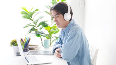 Video konferansı, evden çalışma, Asyalı bir adamın sanal ağ ile iş ekibine video görüşmesi, evdeki bilgisayardan iş arkadaşlarıyla konferans görüşmesi, internet üzerinden iş arkadaşı görüşmesi, internet danışma işi.