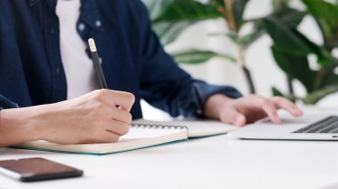 Çevrimiçi eğitim öğrenimi, evden çalışma, dizüstü bilgisayar kullanırken el yazısı, yetişkin erkek öğrenci çevrimiçi kursu  