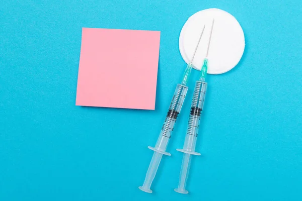 Očkování nebo revakcinace koncepce - dvě lékařské stříkačky na modrém stole — Stock fotografie