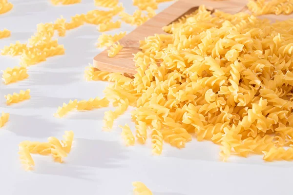 Ungekochte Fusilli-Pasta auf Holzbrettern verstreut — Stockfoto