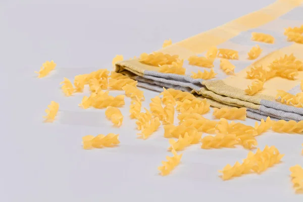 Pâtes Fusilli non cuites éparpillées sur une table blanche — Photo