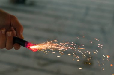 Firecracker 'ı kıvılcımla yakmak. Elinde Petard Tutan Adam