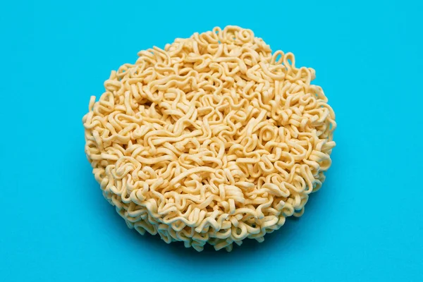 Uncooked Instant Noodles on Blue Background