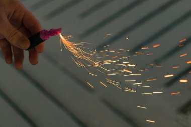 Firecracker 'ı kıvılcımla yakmak. Elinde Petard Tutan Adam