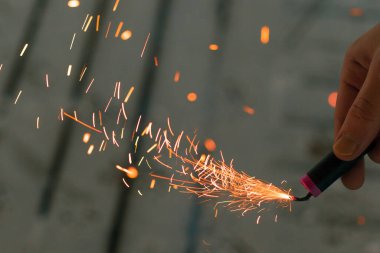 Firecracker 'ı kıvılcımla yakmak. Elinde Petard Tutan Adam