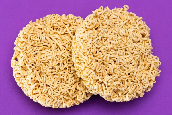 Uncooked Instant Noodles on Violet Background