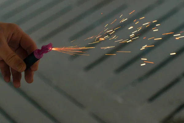 A queimar foguetes com faíscas. Cara segurando um Petard em uma mão — Fotografia de Stock