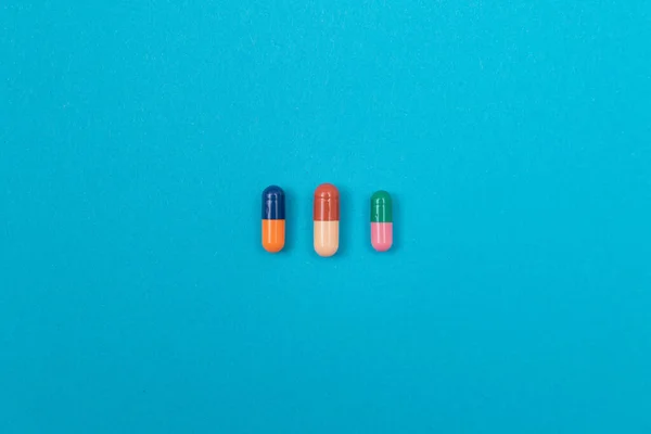 医薬品業界と医薬品-青いテーブルの上の色の薬 — ストック写真