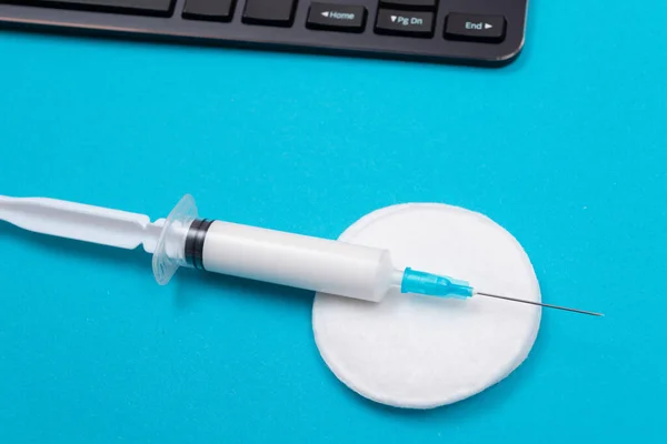 Koncepcja szczepień lub szczepień przypominających - strzykawka medyczna na niebieskim stole — Zdjęcie stockowe