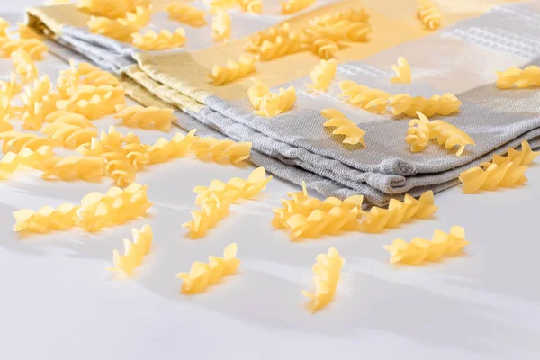 Ungekochte Fusilli Pasta auf weißem Tisch verstreut — Stockfoto