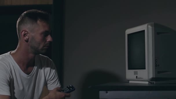 Ovládání mysli - Zombified Man in White T-shirt Switches Channels on the TV — Stock video