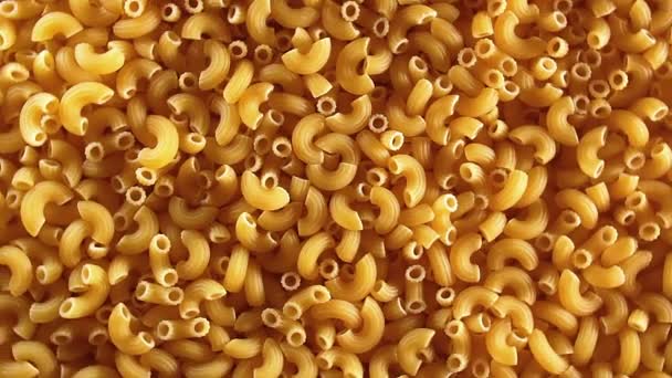 Pâtes de mousseline Rigati non cuites, macaronis secs éparpillés - Arrière-plan rotatif — Video