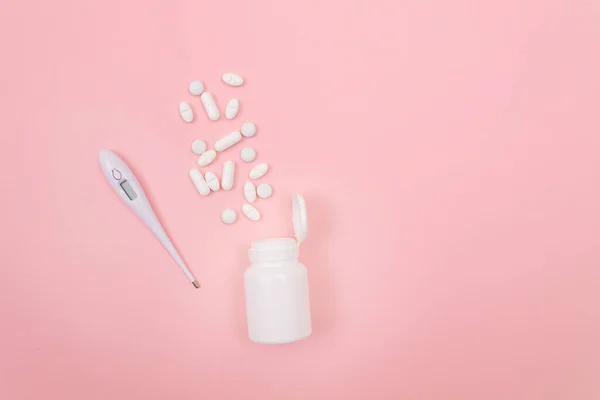 White Pills or Tablets with Electronic Thermometer on Pink Background — Stock Photo, Image