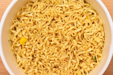 Tahta arka planda tek kullanımlık kupada hazır erişteler