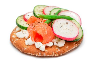 Somon, salatalık, turp, süzme peynir ve yeşil soğanlı krakerli sandviç.