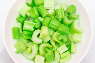 Taze Doğranmış Kereviz Dilimleri ve Beyaz Bulaşık Üzerine Su Damlaları - Üst Görünüm