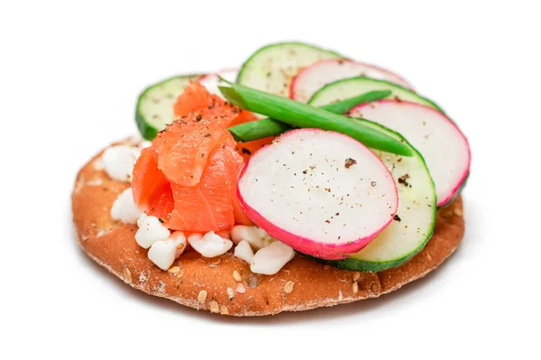 Kanapka z krakersem z łososiem, ogórkiem, rakiszem, serem wiejskim i zielonymi cebulkami - izolowane — Zdjęcie stockowe