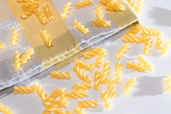 Ungekochte Fusilli Pasta auf weißem Tisch verstreut — Stockfoto