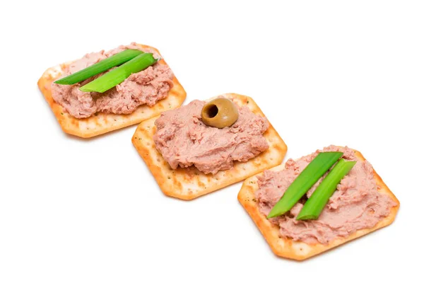 Knusprig gesalzene Cracker mit Leberpastete, grünen Zwiebeln und Oliven - isoliert — Stockfoto