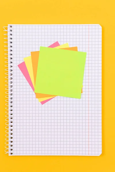 Un bloc de notas con notas adhesivas en la tabla amarilla — Foto de Stock