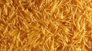 Saat Yönünün Tersine Yavaşça Dönen Pişmemiş Eriştelerin Arkaplanı - Üst Görünüm, Açısal Döndürme. Kuru Vermicelli Dönüşü dokusu. Low Key Light ile Çiğ Makarna - Sol Çevirme