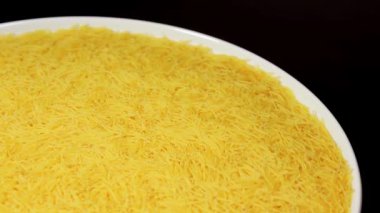 Raw Uncooked Noodles on White Plate Rotating against Black Background. Dry Vermicelli Turning Around. Raw Pasta