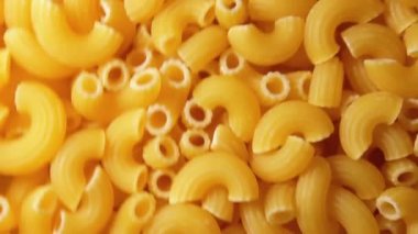 Uncooked Chifferi Rigati Pasta - Top View. Fat and Unhealthy Food. Classic Dry Macaroni, Rotating Background. Italian Culture and Cuisine. Raw Golden Pasta Texture - Side Rotation Left