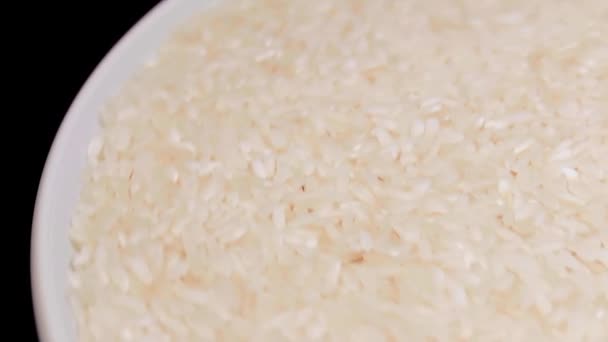 Dry Uncooked White Rice White Plate Rotating Black Background Scattered — Stock video