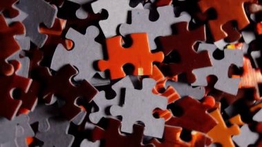 Saat Yönünün Tersine Yavaşça Dönen Renkli Bulmaca Parçalarının Arkaplanı - Üst Görünüm, Yakın Çekim. Tamamlanmamış kırmızı ve gri yapbozun dokusu - Sol Döndürme