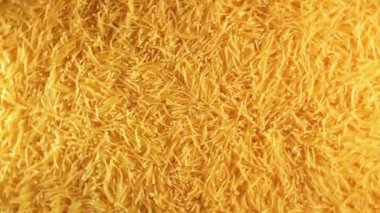 Background of Uncooked Golden Noodles that Rotating Counterclockwise - Top View. Texture of Dry Vermicelli Turning Around. Raw Pasta - Left Rotation
