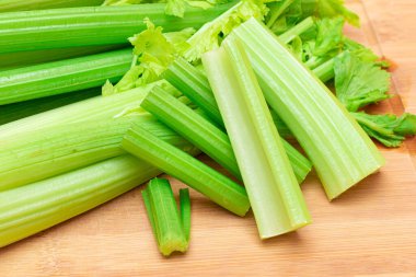 Taze Kereviz Kökü ve Tahta Kesme Tahtasında Doğranmış Kereviz Çubukları. Vejetaryen ve Vejetaryen Kültürü. Çiğ yemek. Sağlıklı beslenme ve negatif kalori içeriği. Zayıflatıcı Gıda