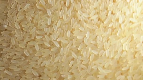 Dry Uncooked Parboiled Rice Background Rotating Clockwise Top View Scattered — ストック動画