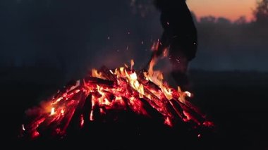 Büyük Kamp Ateşi, Sabah Erkenden veya Akşam Mavi Gök 'e Karşı Yanıyor. Ateşe odun. Uçan Kıvılcım. Seyahat ve Turizm Konsepti. Yazın Devasa Şenlik Ateşi 'nden Kalanlar - Sabit Çekim, Yavaş Hareket