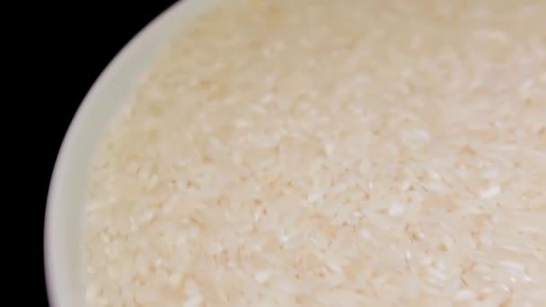 Dry Uncooked White Rice White Plate Rotating Black Background Scattered – stockvideo