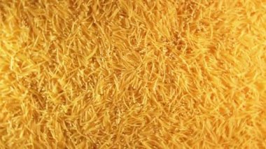 Background of Uncooked Golden Noodles that Rotating Clockwise - Top View. Texture of Dry Vermicelli Turning Around. Raw Pasta - Right Rotation