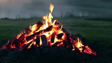 Big Campfire is Burning Down in Early Morning. Wood on Fire. Flying Sparks. Travel and Tourism Concept. Remains of a Giant Bonfire at Summer - Static Shot, Slow Motion