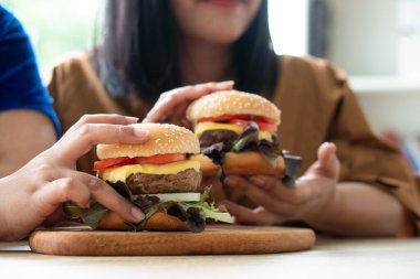 İşten eve gelirken elinde hamburgerle dolaşan aç şişman bir kadın kilo alma sorunu yaşıyor. Aşırı yeme bozukluğu kavramı (BED).