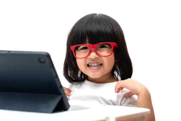 Happy Little Asian Prechooler Girl Wearing Red Glasses Using Tablet — стоковое фото