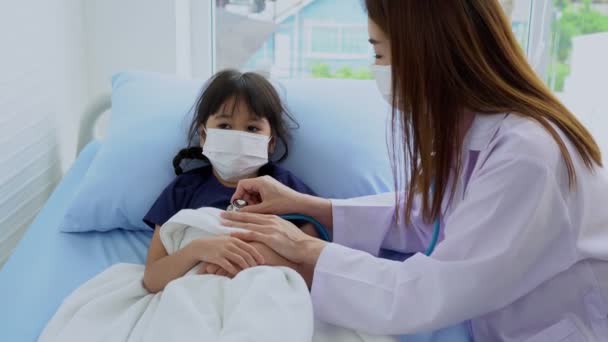 专业的亚洲女医生用听诊器倾听小女孩的心跳 握住病人的手 在医院 护理概念和同情心方面鼓励和提供医疗建议 — 图库视频影像