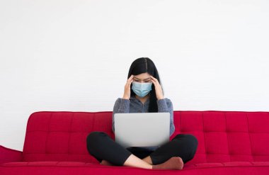 Yüz maskesi takan yorgun bir kadın, baş ağrısı ve migren, bilgisayarla uzun saatler çalıştıktan sonra ofis sendromu çekmesi. Ofis sendromu ve sağlık konsepti.