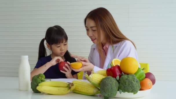 Disfrutar Mamá Asiática Enseñando Una Pequeña Hija Sosteniendo Cuchillo Verduras — Vídeo de stock