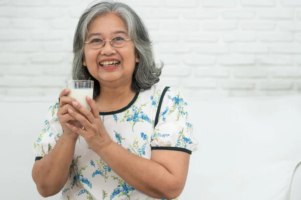 Asiatique Senior Femme Tenant Lait Verre Tout Relaxant Sur Canapé — Photo