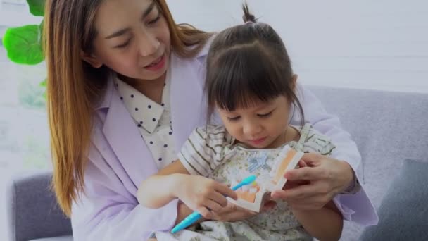 Asiatische Zahnärztin Unterrichtet Süßes Kleines Mädchen Beim Zähneputzen Mit Zahnbürste — Stockvideo