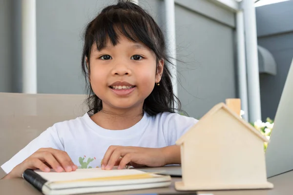 亚洲女学生在网上学习和在家里做作业时使用笔记本电脑 为儿童提供教育和远距离学习的概念 — 图库照片
