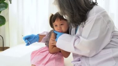 Enjeksiyon için Asyalı doktor şırıngası iğnesi, çocuklar koronavirüs ve grip önleme aşısı oluyor. Aşıdan gelen bağışıklık kavramı